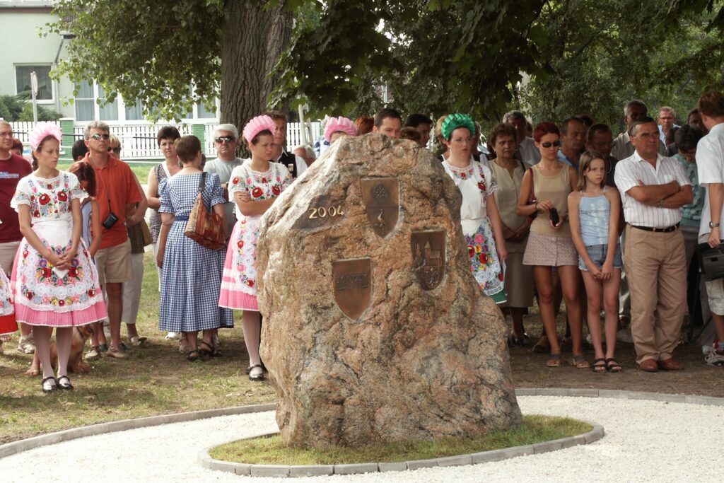 Partnerschaftsstein in Nagyvenyim Großer Stein mit Menschen, teilweise in Tracht