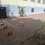Schülerplatz mit Spielzeughütten, Tretwagen und Sichtungskonfektion auf einem Schulhof.