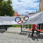 Olympische Knaxiade – Buntband mit Olympischen Ringen auf einem Wegen.