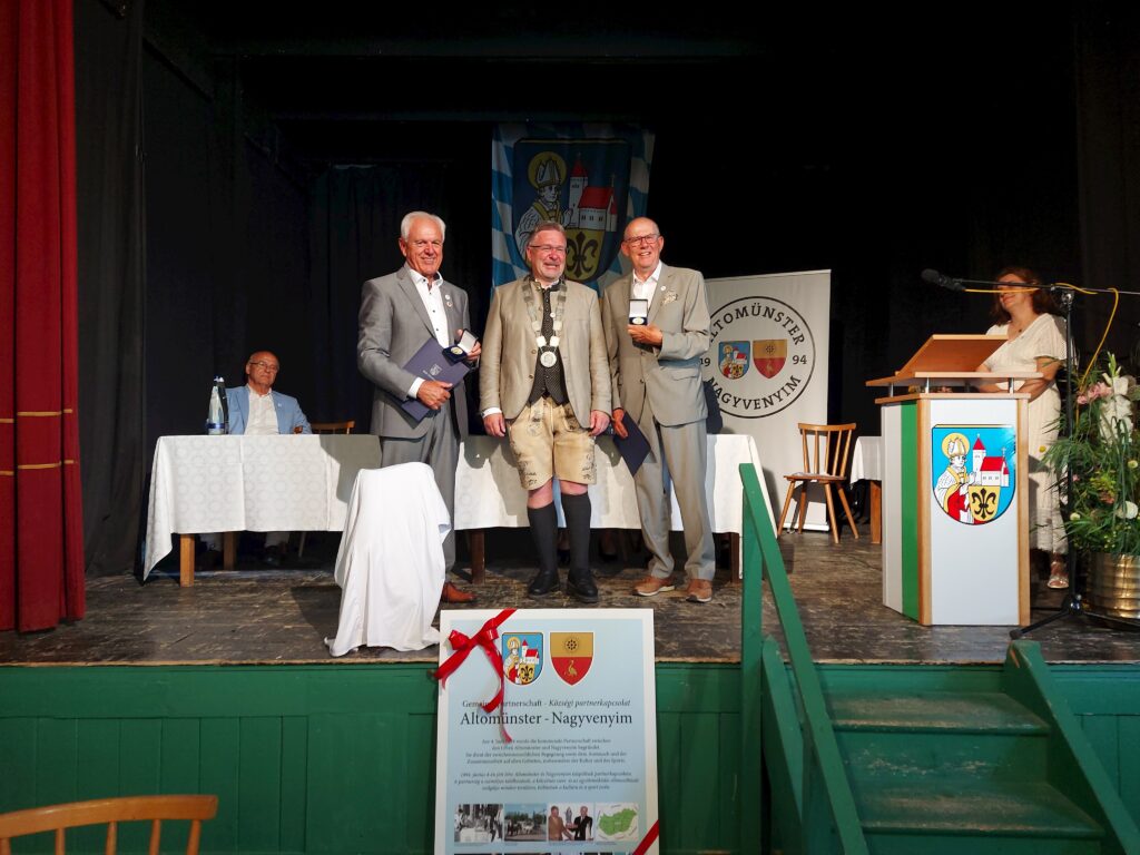 Gemeindepartnerschaft Altomünster – Nagyvenyim Eröffnungskerzenrunde mit Ehrenzeichen auf Ständern.