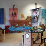 Piratenschiff in Klassenzimmer, festlich dekoriert mit Flaggen und Schiffsdekor.