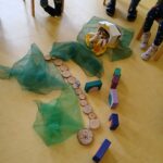 Kinderspielmaterial auf dem Boden, mit Spielzeug und Farben.