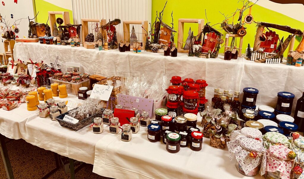 Markt Altomünster - Trockenes Winterschneerest in Glas und Kissen, mit bunten Produkten und dekorativen Gegenständen.