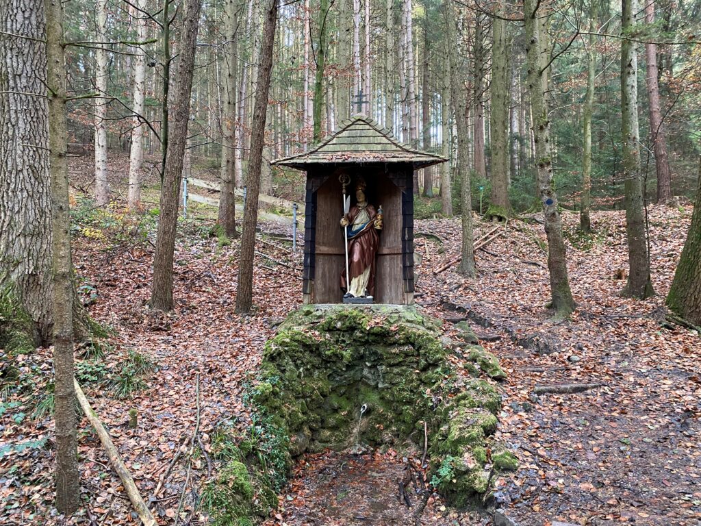 Altomünster im Wald, Gottessäule mit Statue und Wasserquelle.