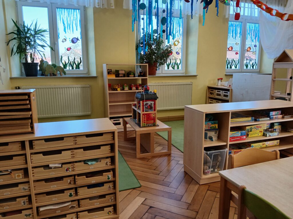 Schmücktes Kindergartenraum mit Spielzeug und Pflanzen.