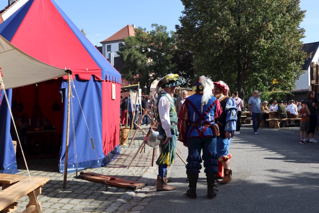 Markt Altomünster: Markt mit Zelt, Trachten und Besuchern.