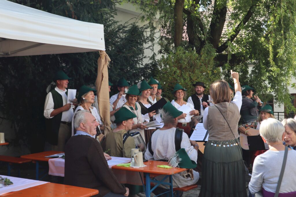 Chor mit traditionellen Kleidern und grünen Hüten im Marktplatz Altomünster.