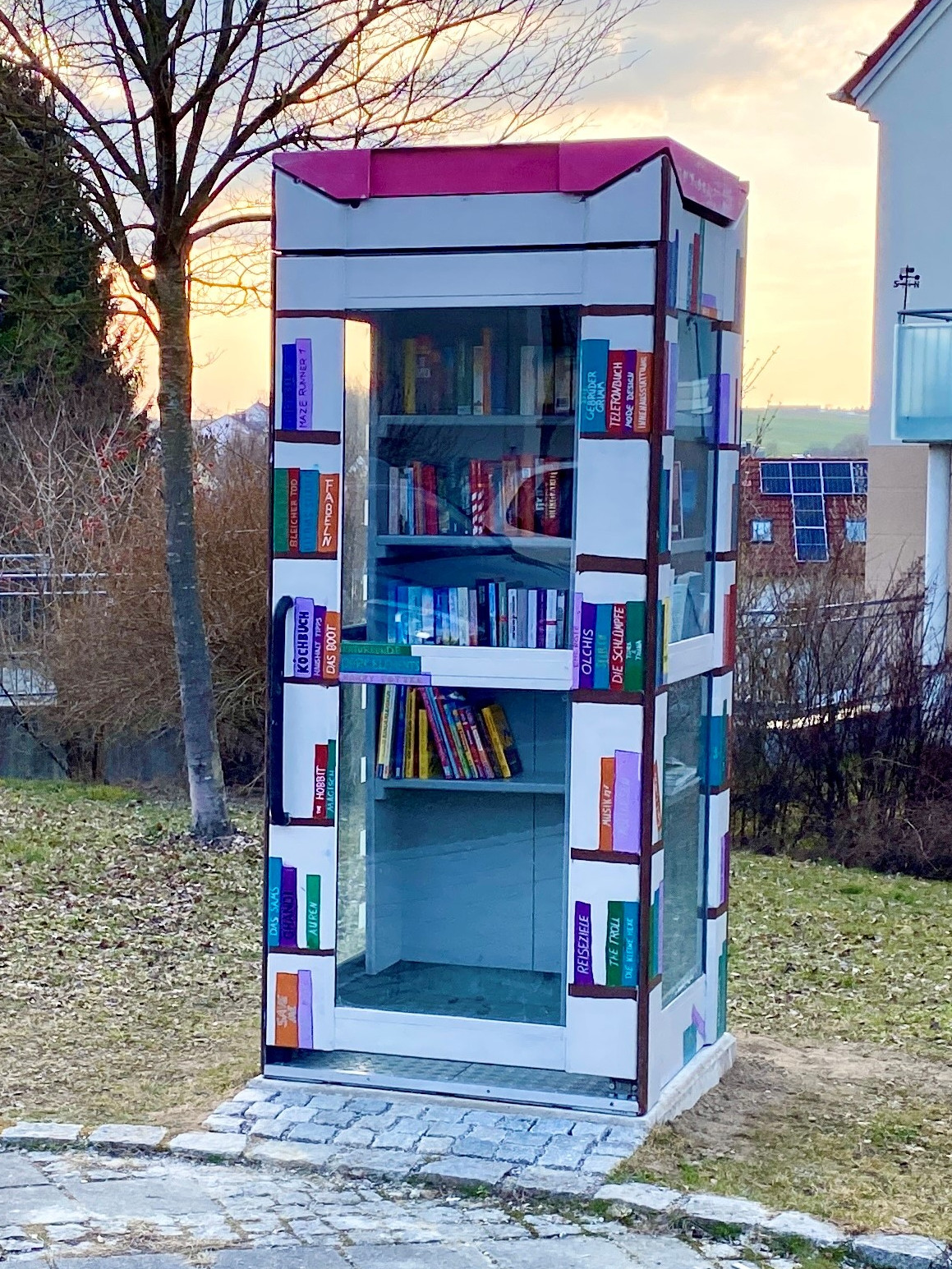 Ein Bücherkiosk mit bunten Bucheinbänden im Park.