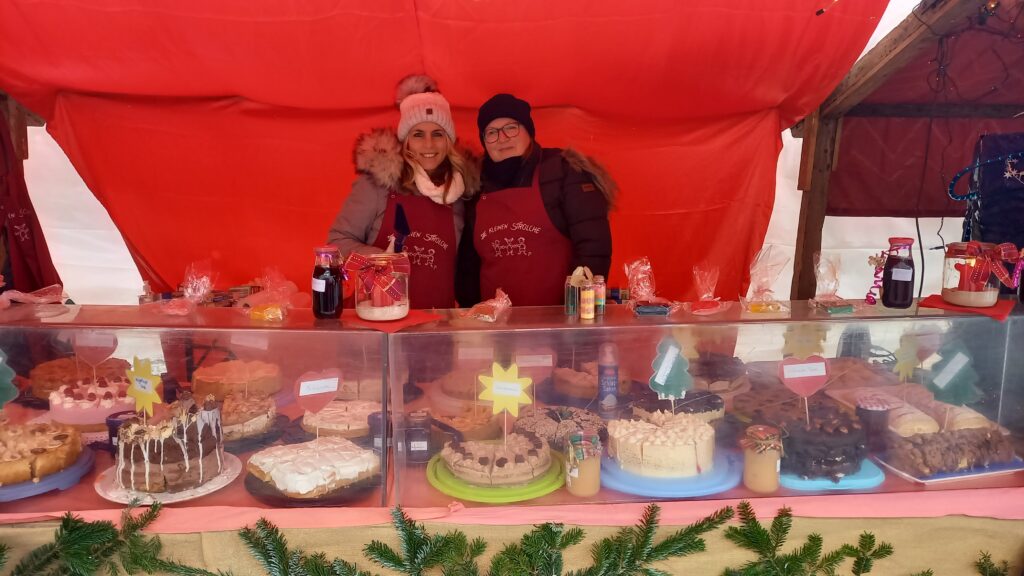 Märkte in Altomünster mit Tüten und Gebäck unter rotem Markenstoff.