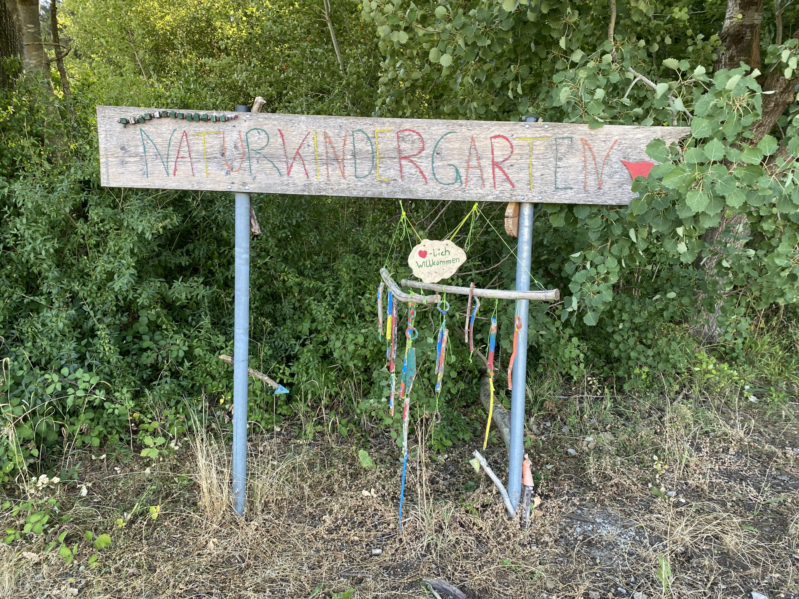 Eingang Natürlichkindergarten mit bunten Dekorationen im Wald.