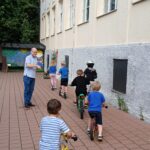 Kindern auf der Spielplatzscheibe mit Fahrrädern