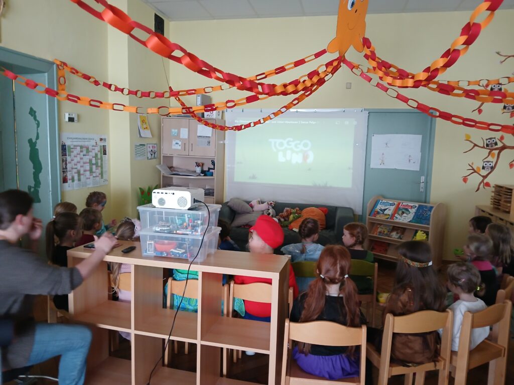 Kinder in einem Klassenzimmer bei einer Projektion.