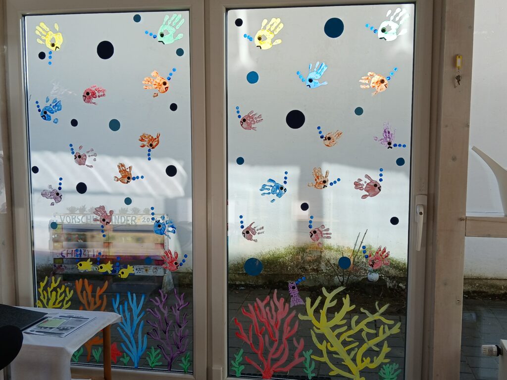 Familienfreundliches Kinderzelt mit bunten Handabdrücken und Korallen.