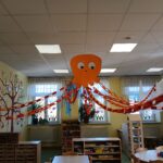 Ein Kinderzimmer mit einer großen, orangefarbenen, lächelnden Oktopusdekoration.