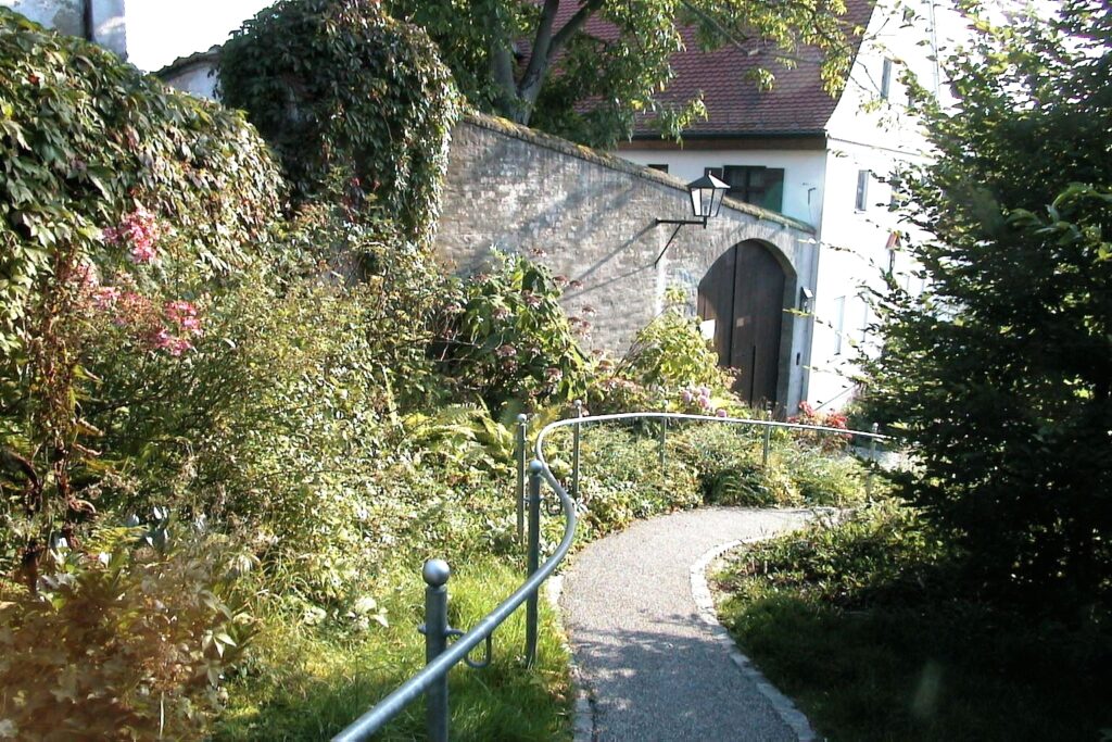 Gartenweg mit Pflanzen und einem Torhaus in Altomünster.