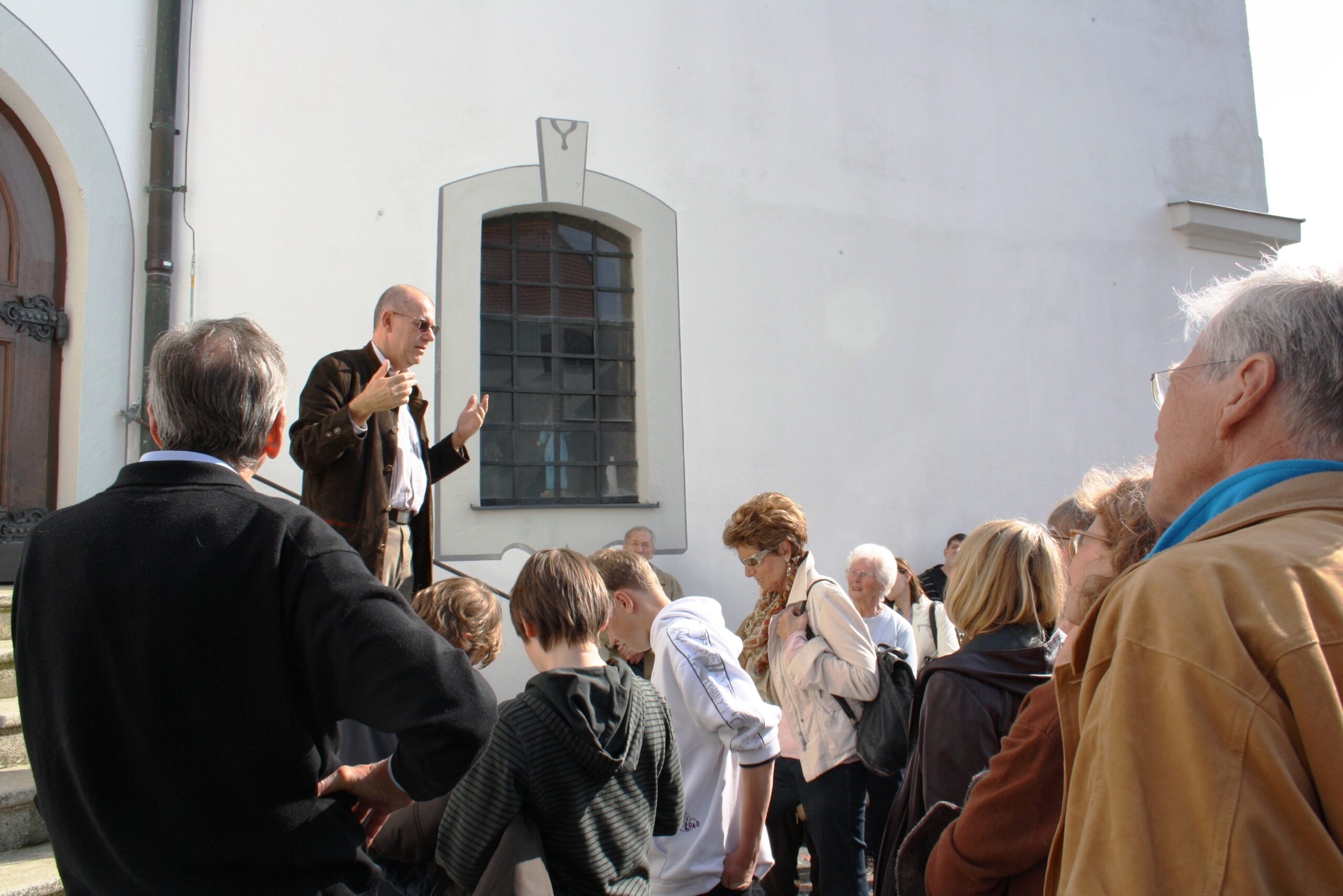 Ein Mann spricht vor einem Publikum auf einem Weg zum Markt in Altomünster.