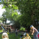 Schüler spielen im Spielplatz mit Bäumen und Obst auf dem Spielplatz in Altomünster.