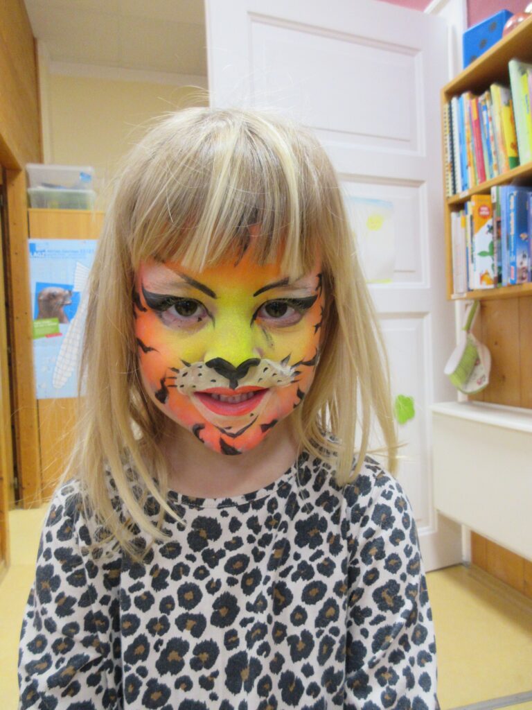 Mädchen mit Färbung eines Tigran in einem Raum.