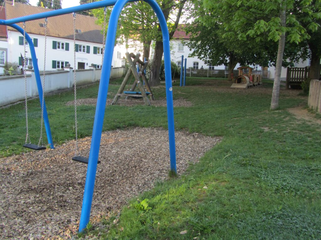 Schau dir die Kinderspielplatz an, mit blauen Schwingbrettern und Spielgeräten.