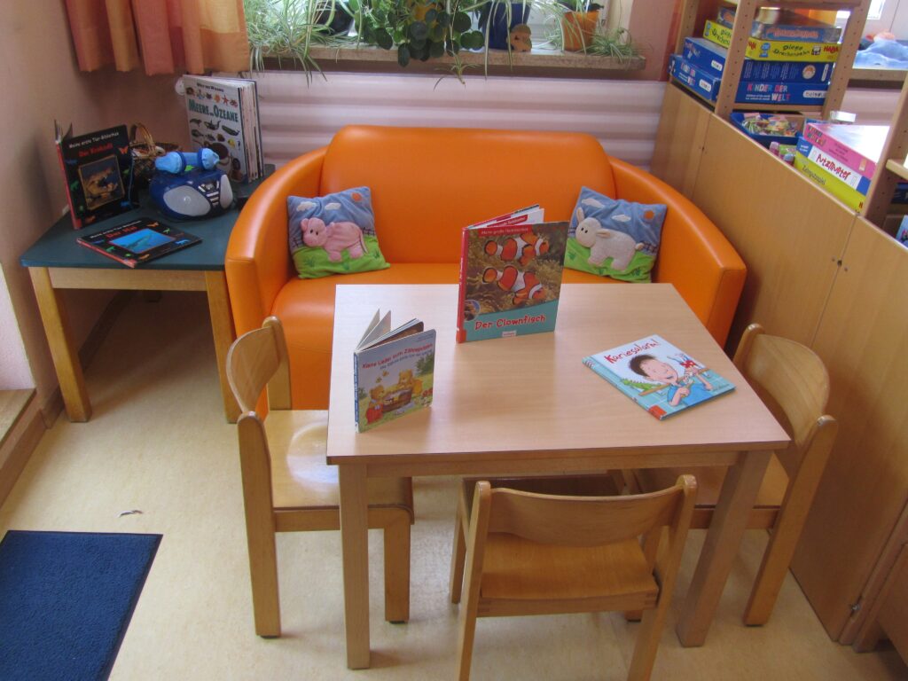 Kindersitzsitz mit Büchern und Spielzeug im Kinderzimmer.
