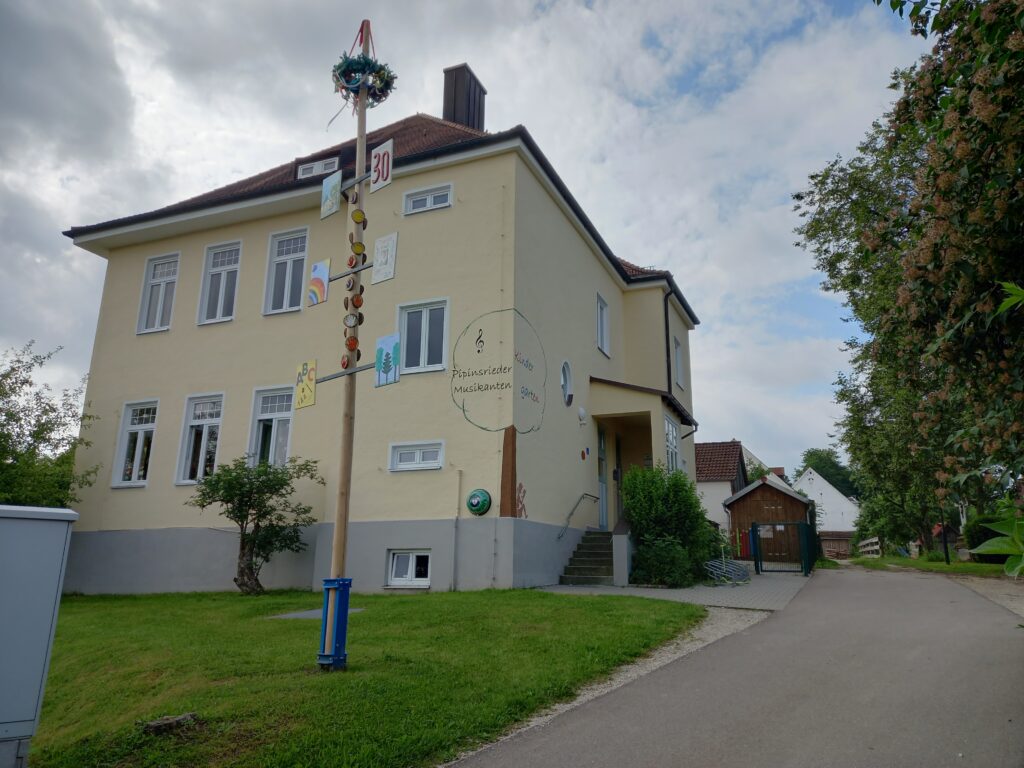 Kindergarten Pipinsrieder Musikantenturm, 30 Jahre alt, mit Tischlerarbeitsplatz, Schule und Spielplatz.