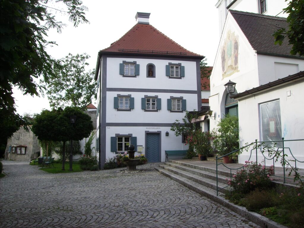 Gesamtansicht des Marktes Altomünster mit Klostertürmchen und gepflasterten Straßen.