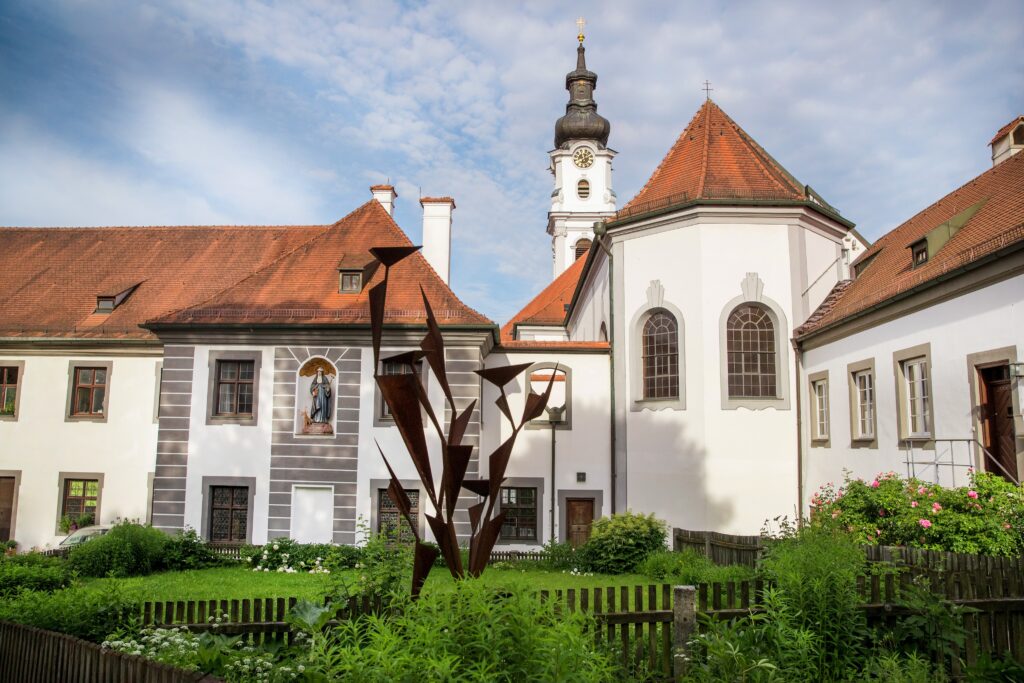 Ein Kirchengebäude mit Turm und Garten im Marktplatz Altomünster.