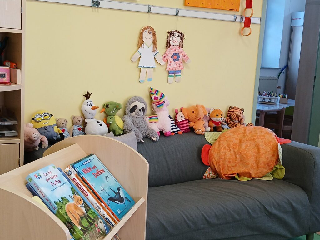 Sitzgruppe mit Plüschtiere und Kinderausgaben in einem freundlichen Kinderzimmer.