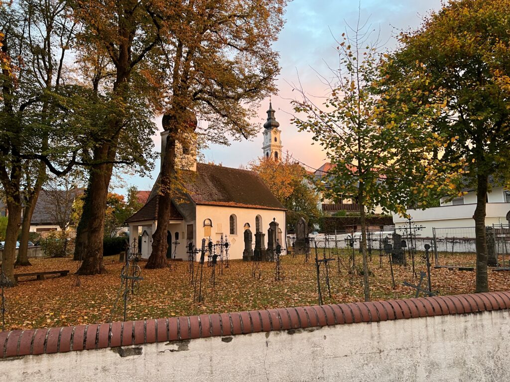 Loretokapelle im Herzen von Altomünster, umgeben von Bäumen und Grabsteinen, zeigt die malerische Kulisse des Marktes.