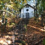 Eine kleine Kirche in der Herde von Altomünster, umgeben von Herbstlaub und Stufen.