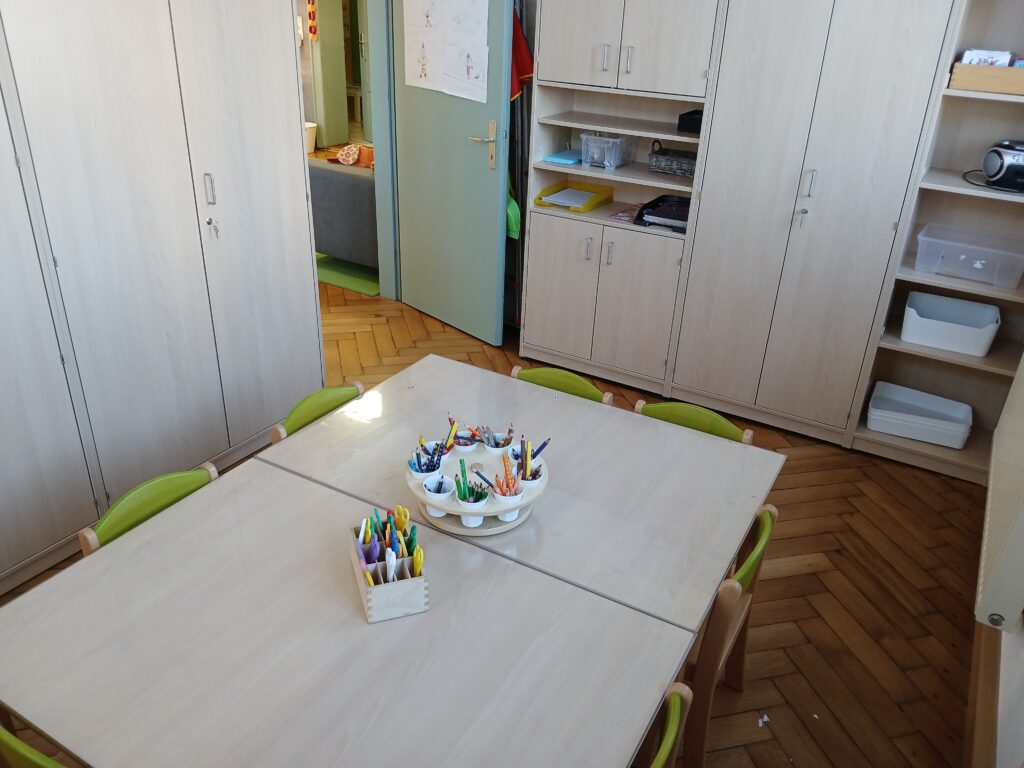Tisch mit Bleistiften, Farben und Gegenständen in einer Kita.