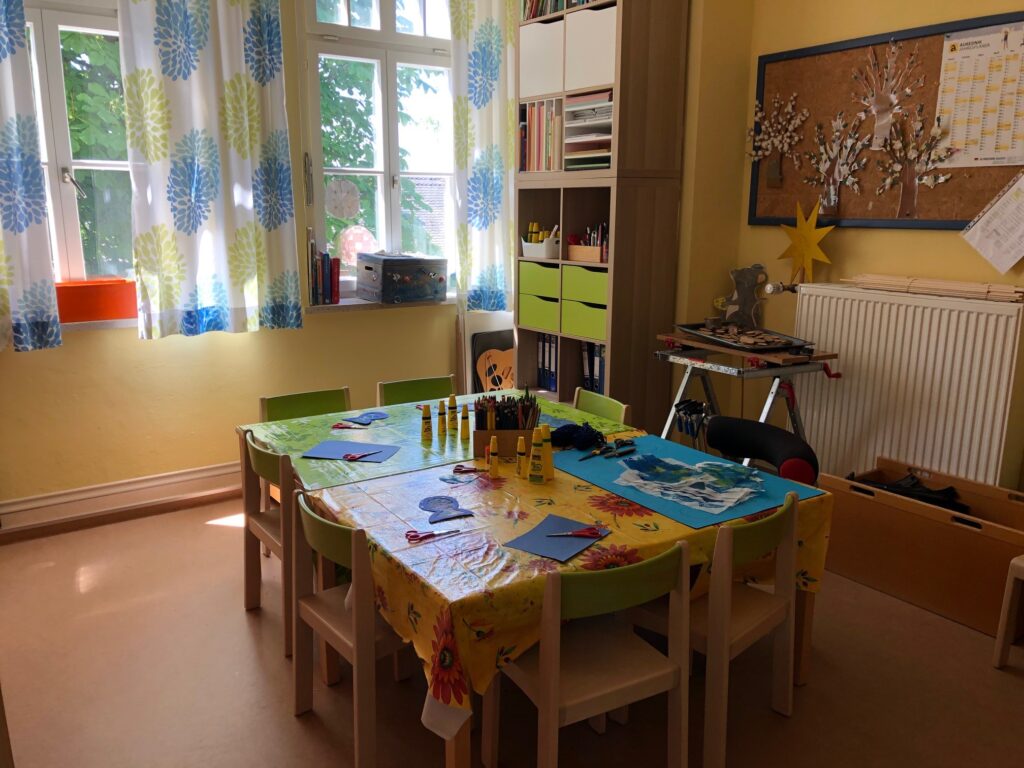 Kreativraum mit Tisch, Möbel und leuchtendem Farbsatz.