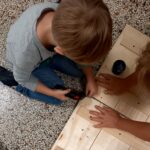 Kind arbeitet mit Holz