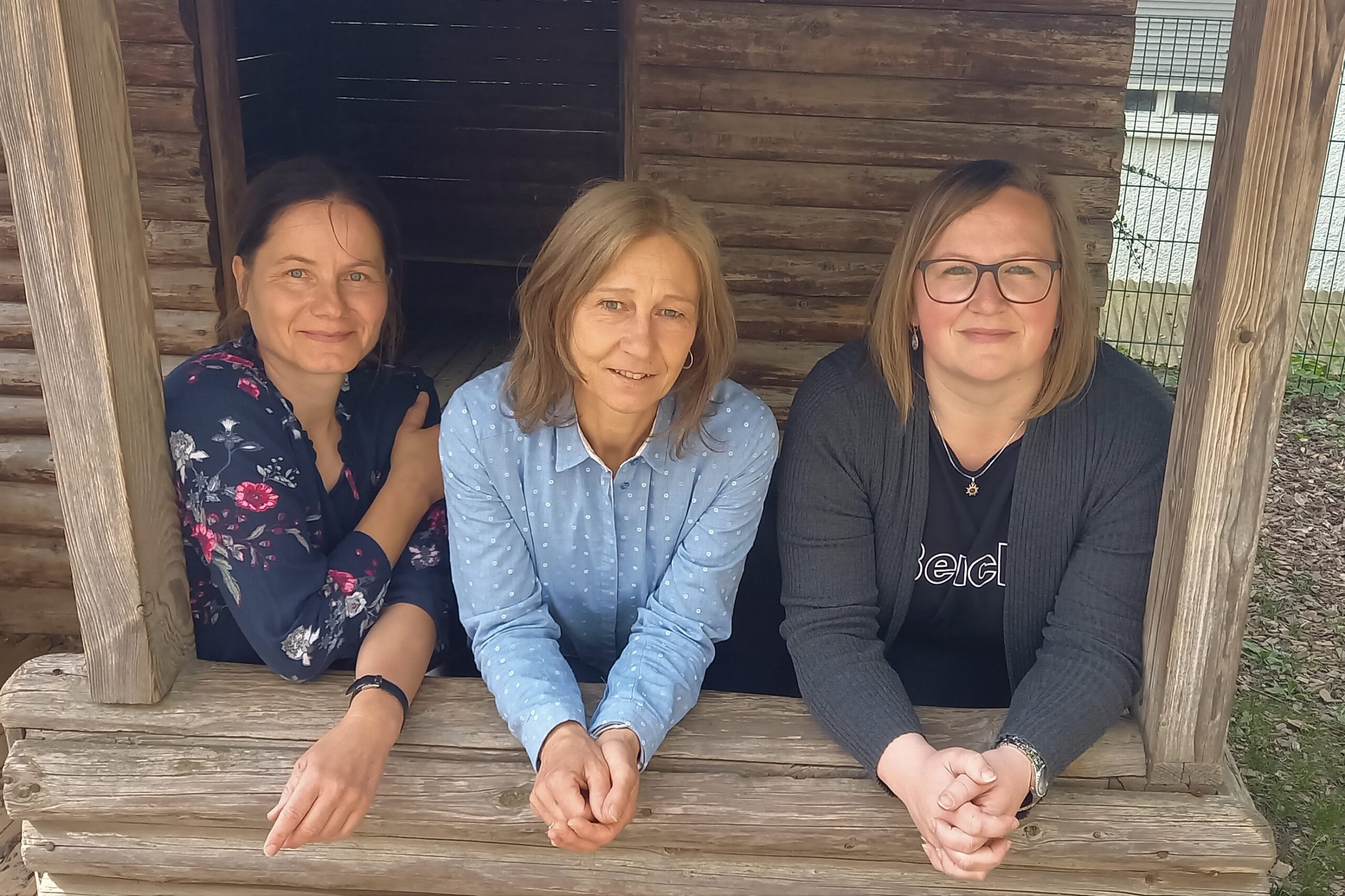 Gruppe Spatz Drei Frauen vor einer Holzstruktur im Marktplatz Altomünster.