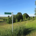 Landschaftsweg 50 min. auf grüner Wiese, blauer Himmel.