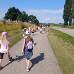 Schule am Weg: Kinder mit Rucksack entlang der Straße.