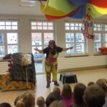 Kleinkunstlerin auf Bühne mit Kindern.