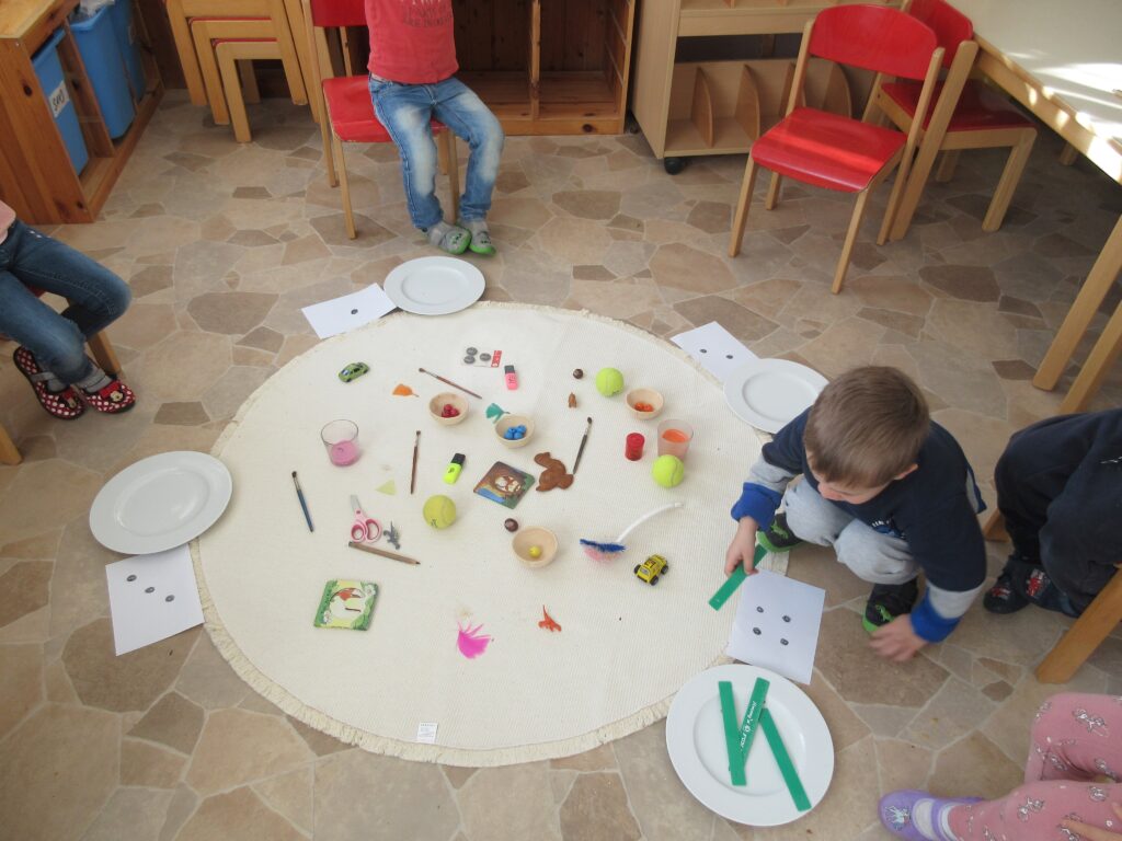 Kinderarbeitsplatz mit Spielzeug und Werkzeug auf einer runden Matte.